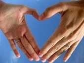 Leona Brokarda fotoattēls ar divām rokām, kas veido sirds formu, simbolizē mīlestību.